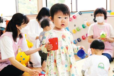 写真：子育て支援室で遊ぶ子どもと一緒に遊び保育士