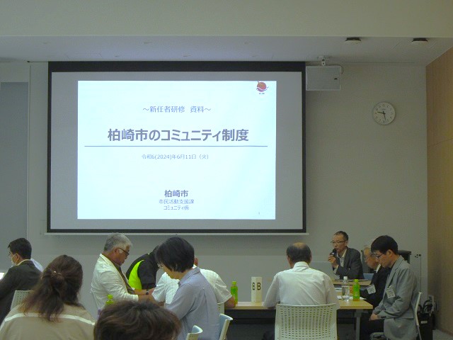 写真：研修会に新任職員が参加した研修会。スライドに研修の資料が映し出されています
