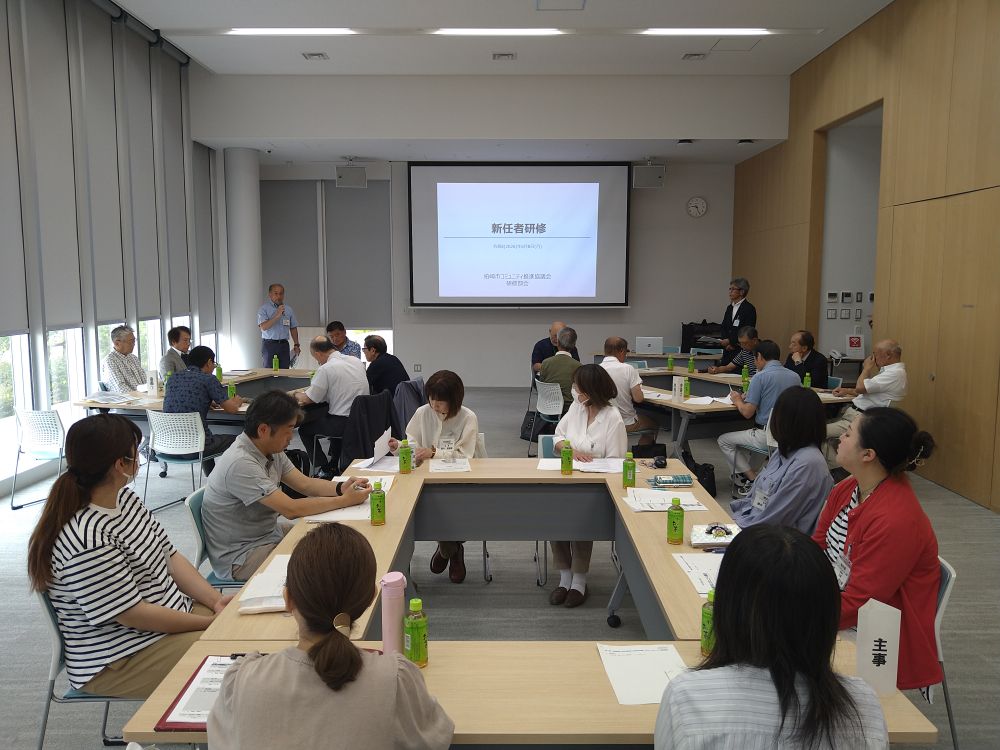 写真：研修会に新任職員が参加した研修会。スライドに研修の資料が映し出されています