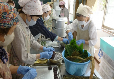 写真：あんを丸める人、草餅にくるむ人など、作業を分担し笹団子を作っています