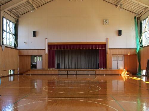 バレーボールコートが1面獲れる講堂（体育館）。前方にはステージもあります。
