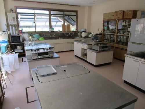 調理実習室。食器棚やコンロ付きの調理台があります