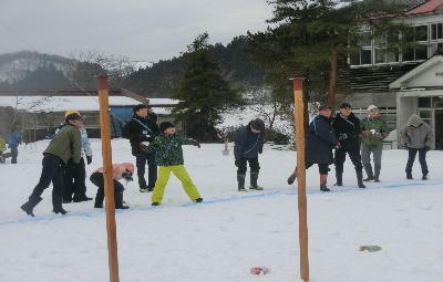 写真：雪の積もった旧別俣小学校のグラウンドで、雪玉を投げて楽しむ子どもたち