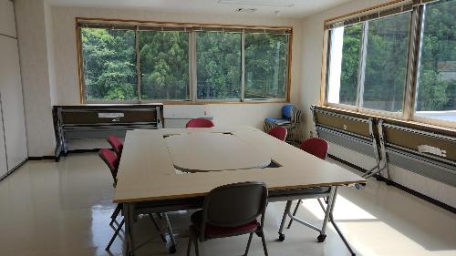 クッションフロアの研修室。中央に2人掛けの机と椅子が並べてあります