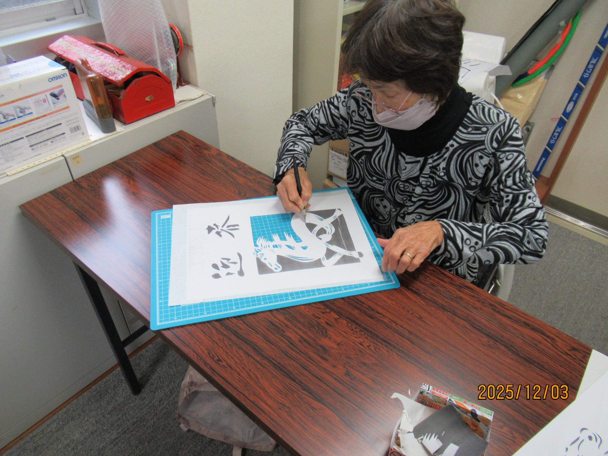 写真：絵柄に沿って、ゆっくりとカッターの刃を動かして紙を切り進めていく受講者