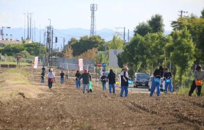 写真：春の時期に、中学生と地域の方が協力して、そばの種蒔きをしているところ