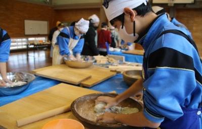 写真：育てたそばの実を挽き、そば粉をこねる中学生たち