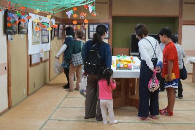 写真：コミセン和室に展示された作品をたくさんのお客さんが見ているところ