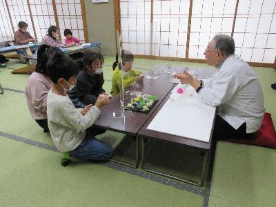 地域の菓子職人からいんころ作りを教わる子どもたちの様子