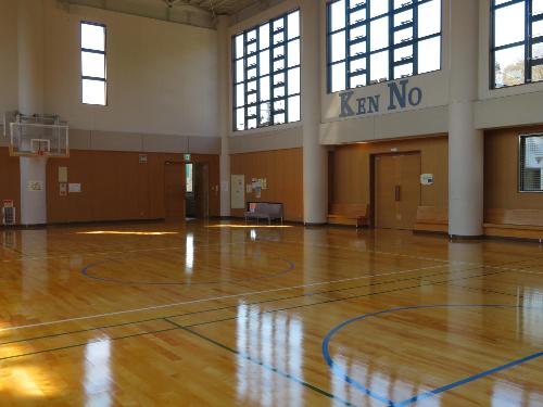 バスケットボールコートが1面獲れる講堂（体育館）。壁側にベンチが備え付けられています。