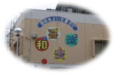 写真：コミュニティセンターの2階外壁に「居心地よい北鯖石で 和・喜・愛・逢」と書かれています