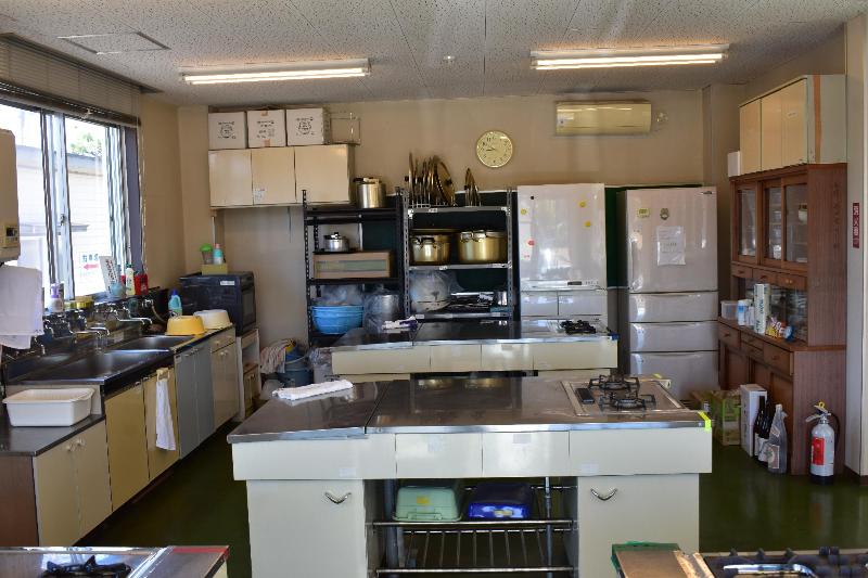 調理実習室。ガスコンロのついた調理台や食器棚、冷蔵庫が備えられています