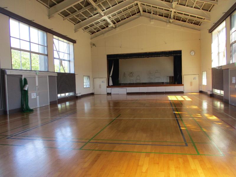 写真：バレーボールコートが1面獲れる講堂（体育館）。前方にはステージもあります