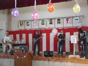 写真：ステージで演奏する男性4人組のバンド