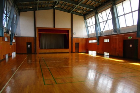 バレーボールコートが1面獲れる講堂（体育館）。前方にはステージもあります