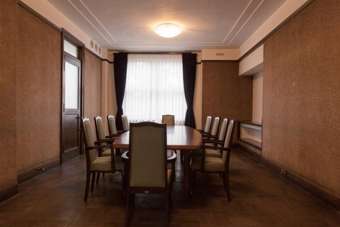 茶色い床と壁の部屋にテーブルとイスが置かれてある写真