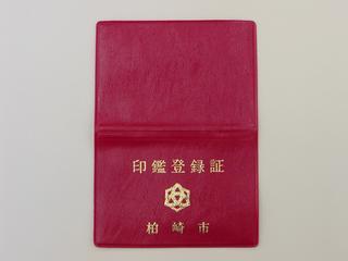 表に金色で印鑑登録証と印字された赤色の印鑑登録証の写真