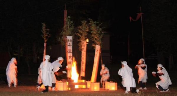 たき火を囲んで7匹の狐が踊りを踊っている写真