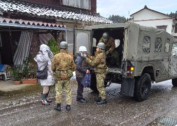 写真：自衛隊の車両に乗り込む地域住民