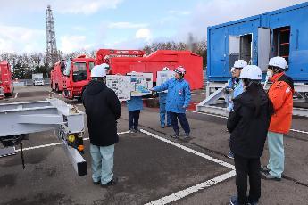 写真：緊急時の除熱・注水機能の概要の説明を受け、現場を確認している様子