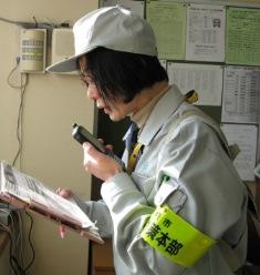 地区本部の女性がIP無線を使い、市本部に連絡している様子の写真