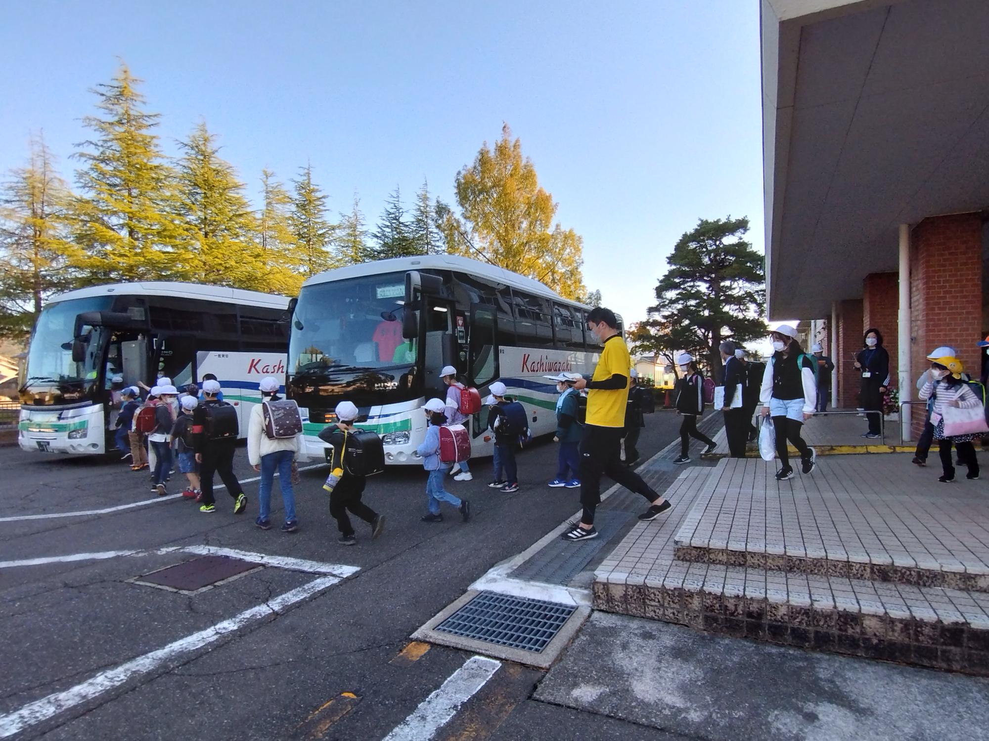 写真：保護者へ引き渡たしができなかった児童がバス避難のためにバスに乗車する様子