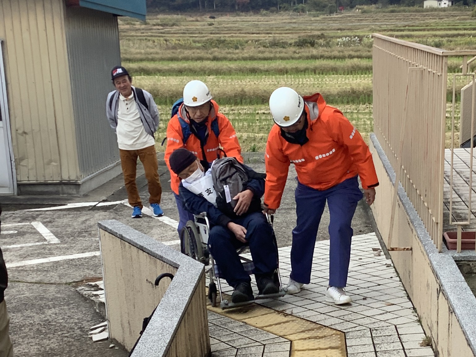 写真：消防団員が車椅子利用者の避難支援を行う様子