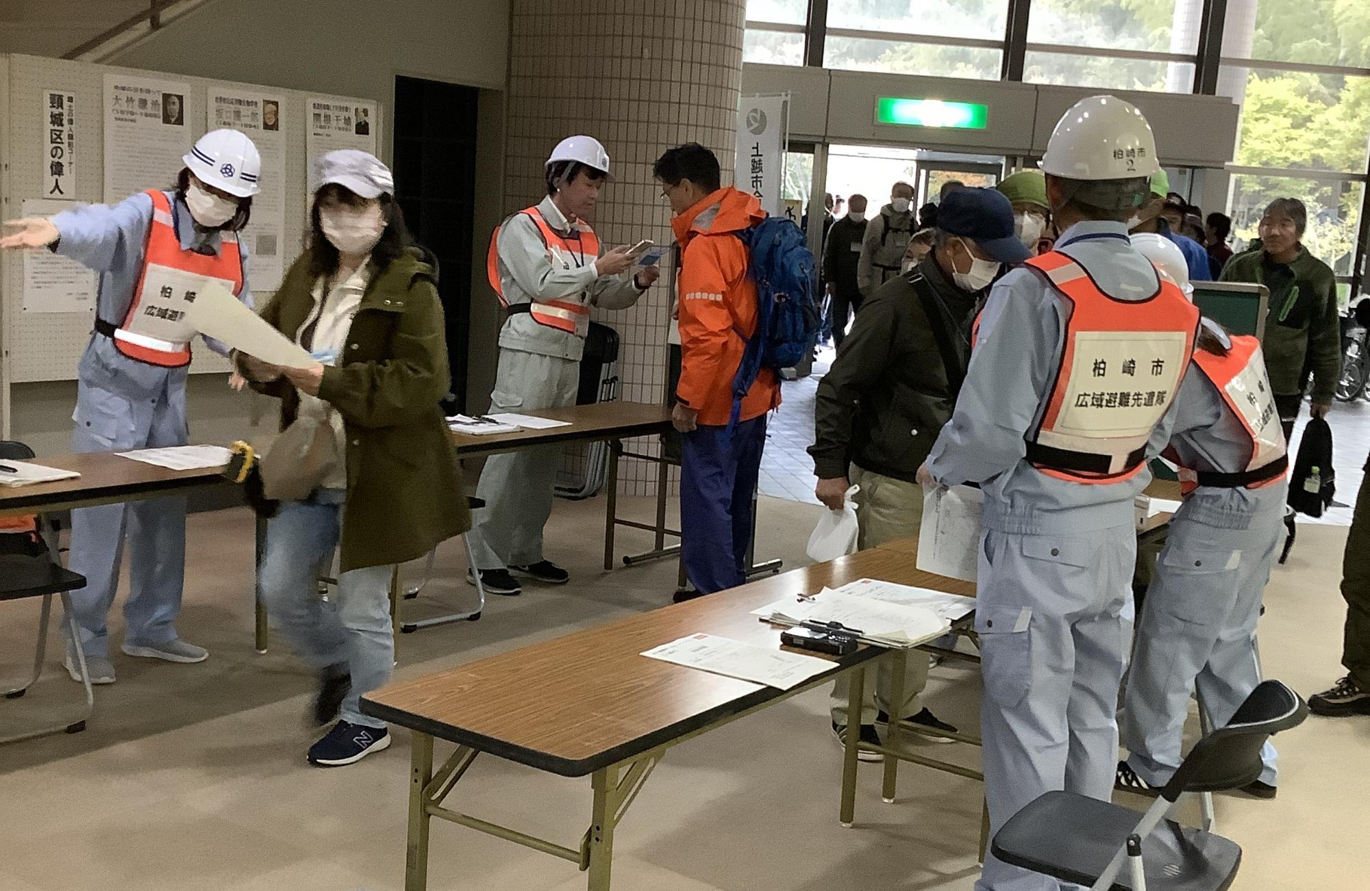写真：避難経由所で職員が避難者の受付、誘導を行う様子