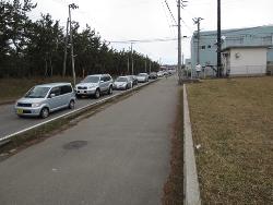 避難訓練中の自家用車が道路の二車線のうち一車線に並んでいる写真