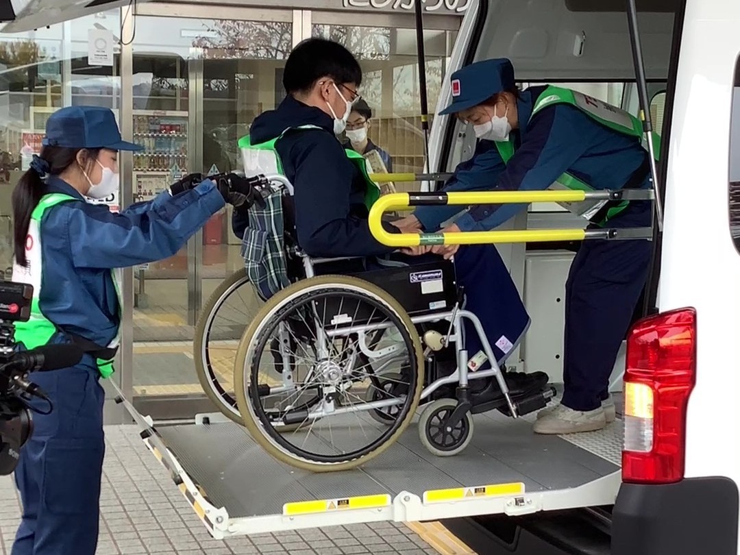 写真：車椅子の避難者役を福祉車両に乗せる時の様子