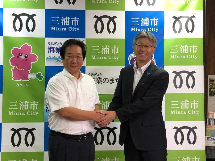 市長が、神奈川県三浦市の吉田市長と握手をしている様子