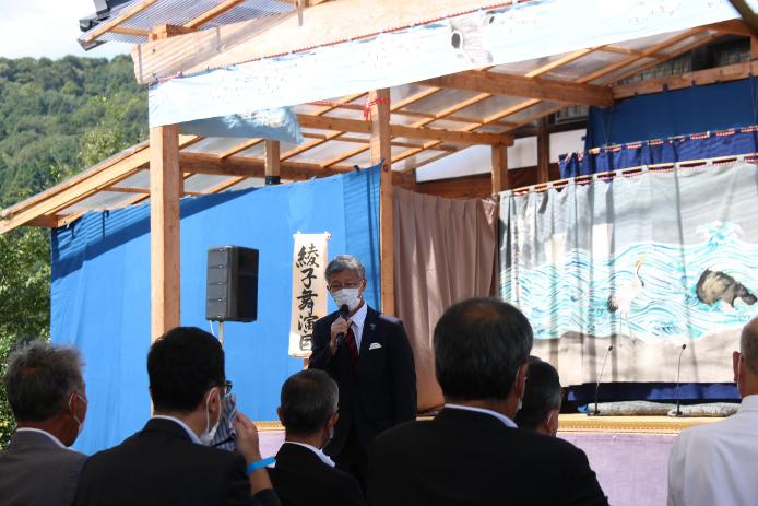 綾子舞現地公開特設ステージの前で、市長がお客さんの前で挨拶をしている様子