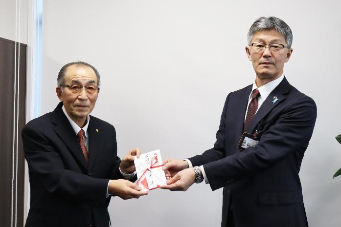 写真：市長が技能検定功労を受賞した藤田さんから寄附金を受領している様子