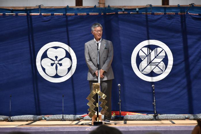 綾子舞会館の特設舞台上で、市長が来場者に対して挨拶をしている様子