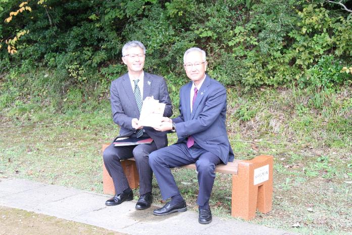写真：市長と柏崎信用金庫の理事長がベンチに座り、目録を受け渡している様子