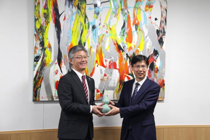 市長が駐新潟中国総領事の崔氏と一緒に、ひょうたん型の青磁を持ち記念撮影している様子
