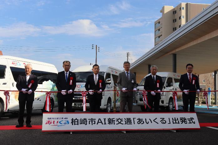 市長が議長や交通事業者とともにAI新交通「あいくる」の車両の前でテープカットをしている様子