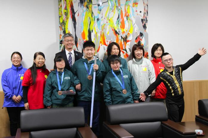 市長がスペシャルオリンピックス柏崎アスリートの選手、保護者と並んで記念撮影している様子