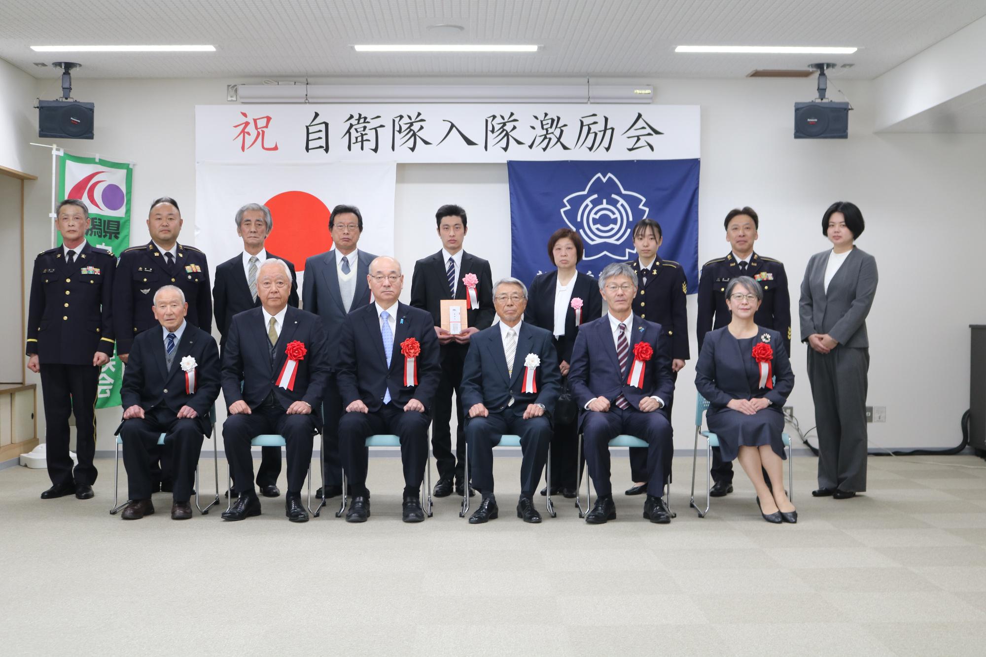 写真：自衛隊入隊予定者と来賓が並んでいます