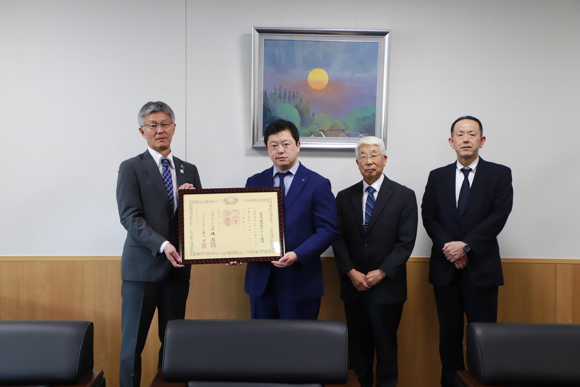 市長が紺綬褒章の章記を渡している。