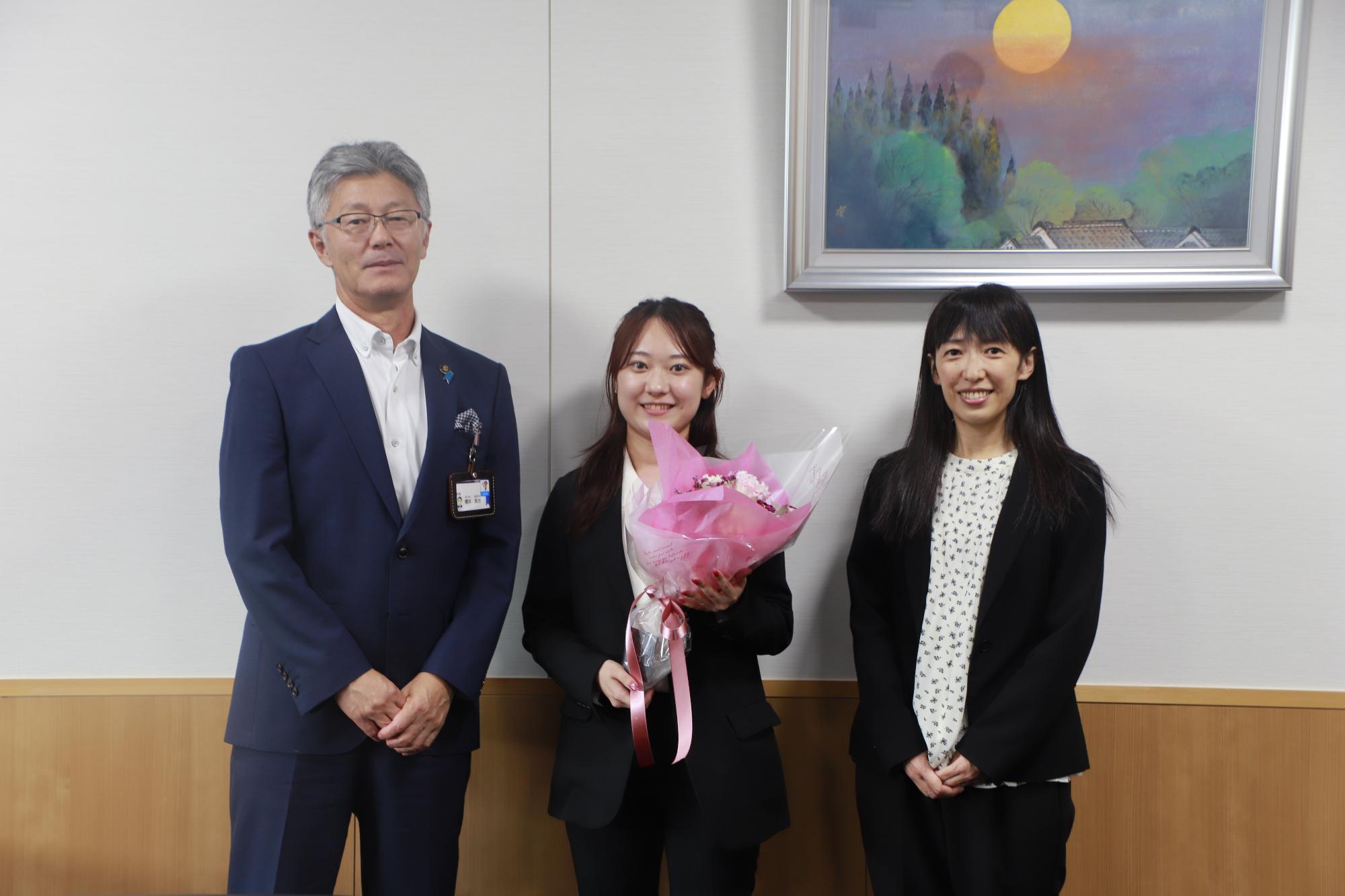 写真：市長（左）と花束を持った佐藤さん（中央）、FMピッカラの高橋さん（右）