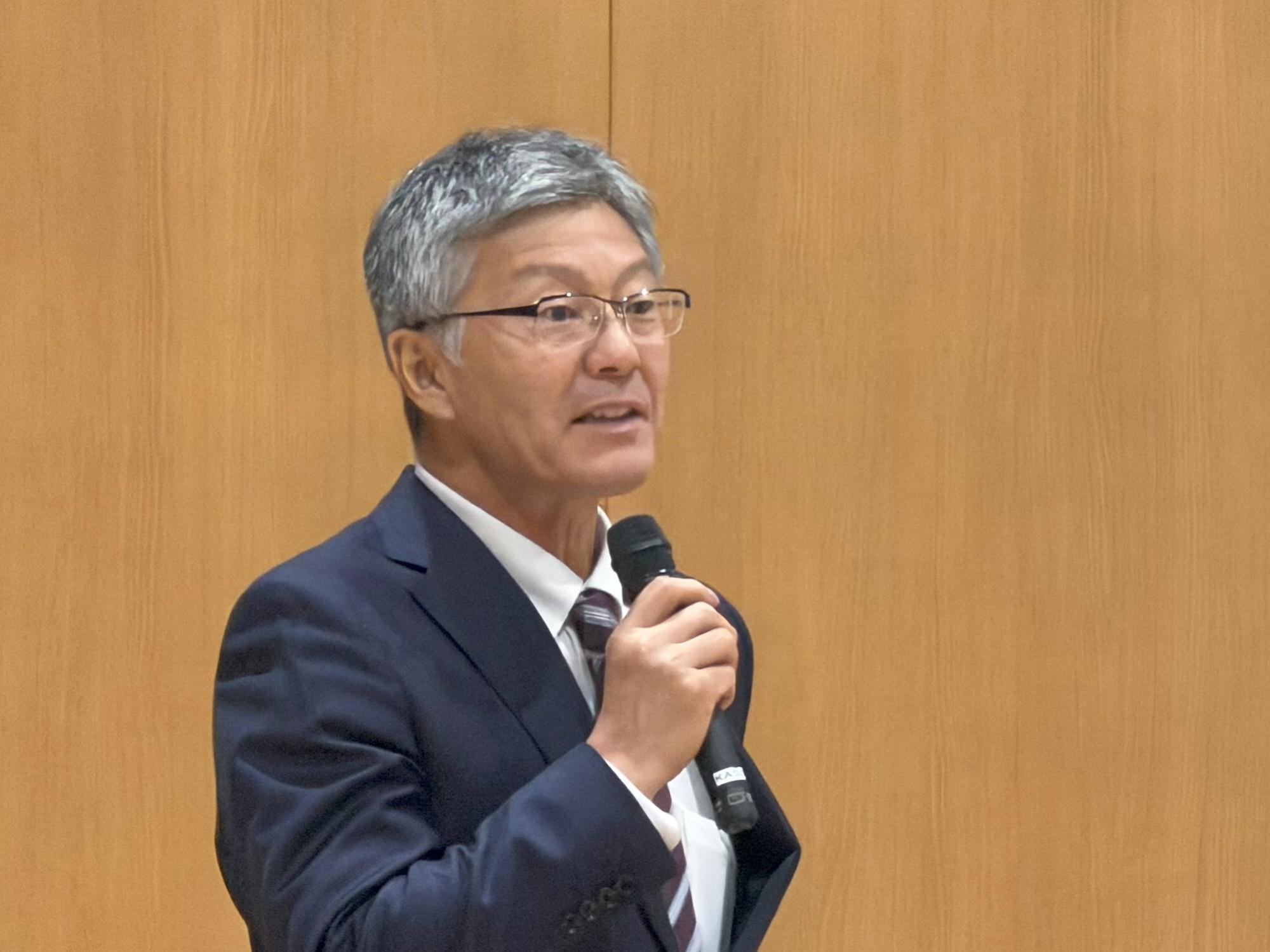 写真：マイクを持ち住民の皆さんと意見交換を行う市長