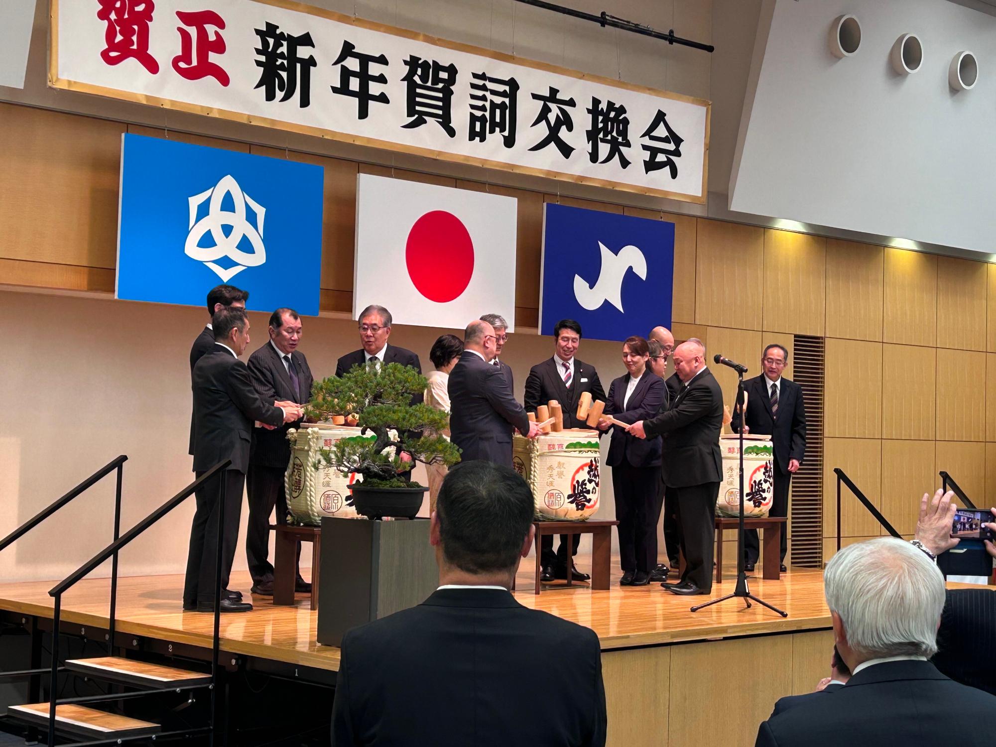 写真：市長と賀詞交換会来賓がステージに登壇し、鏡開きをしているところ