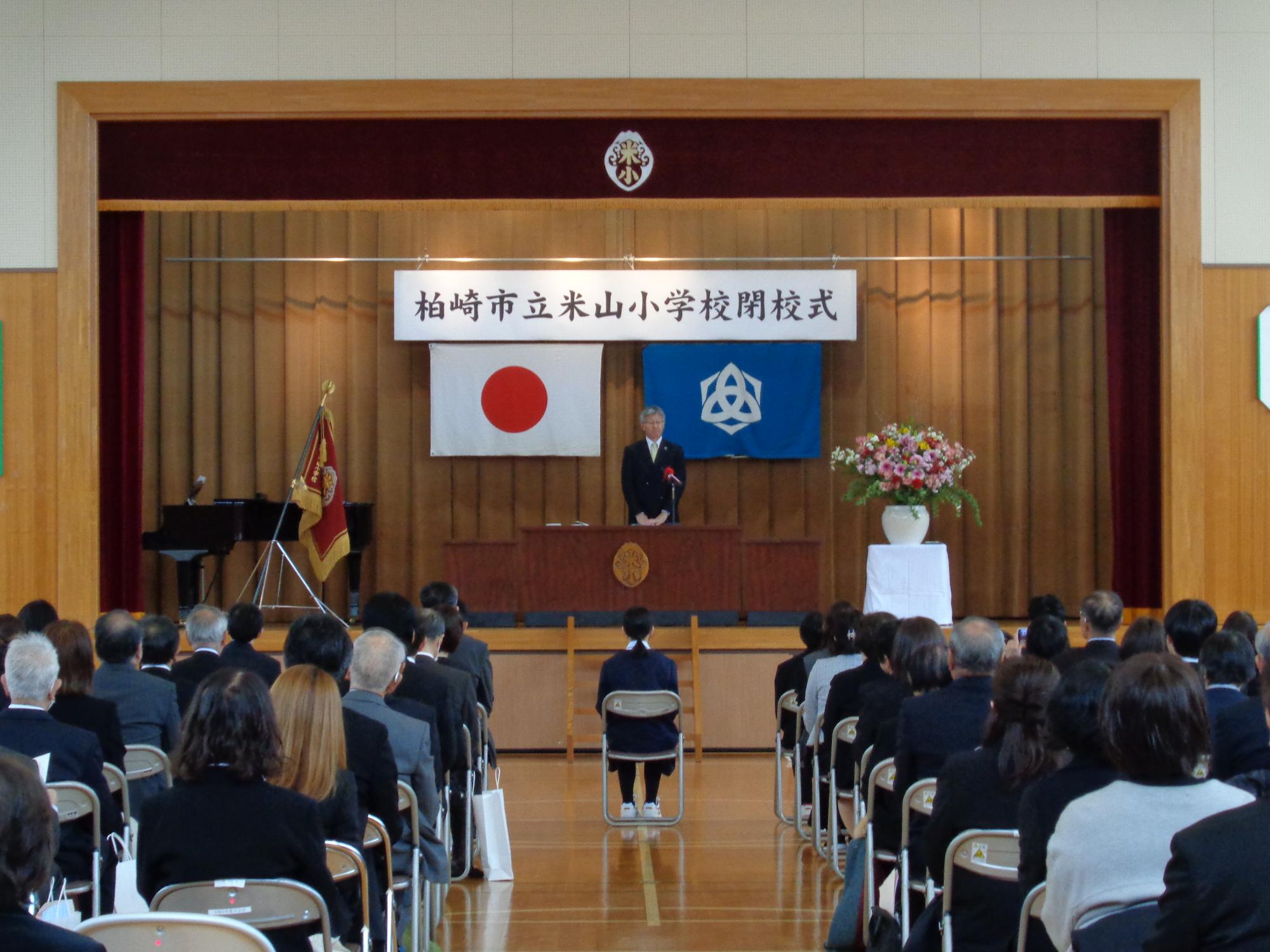 写真：米山小学校閉校式で、参列した児童・地域住民を前に市長が式辞を述べています
