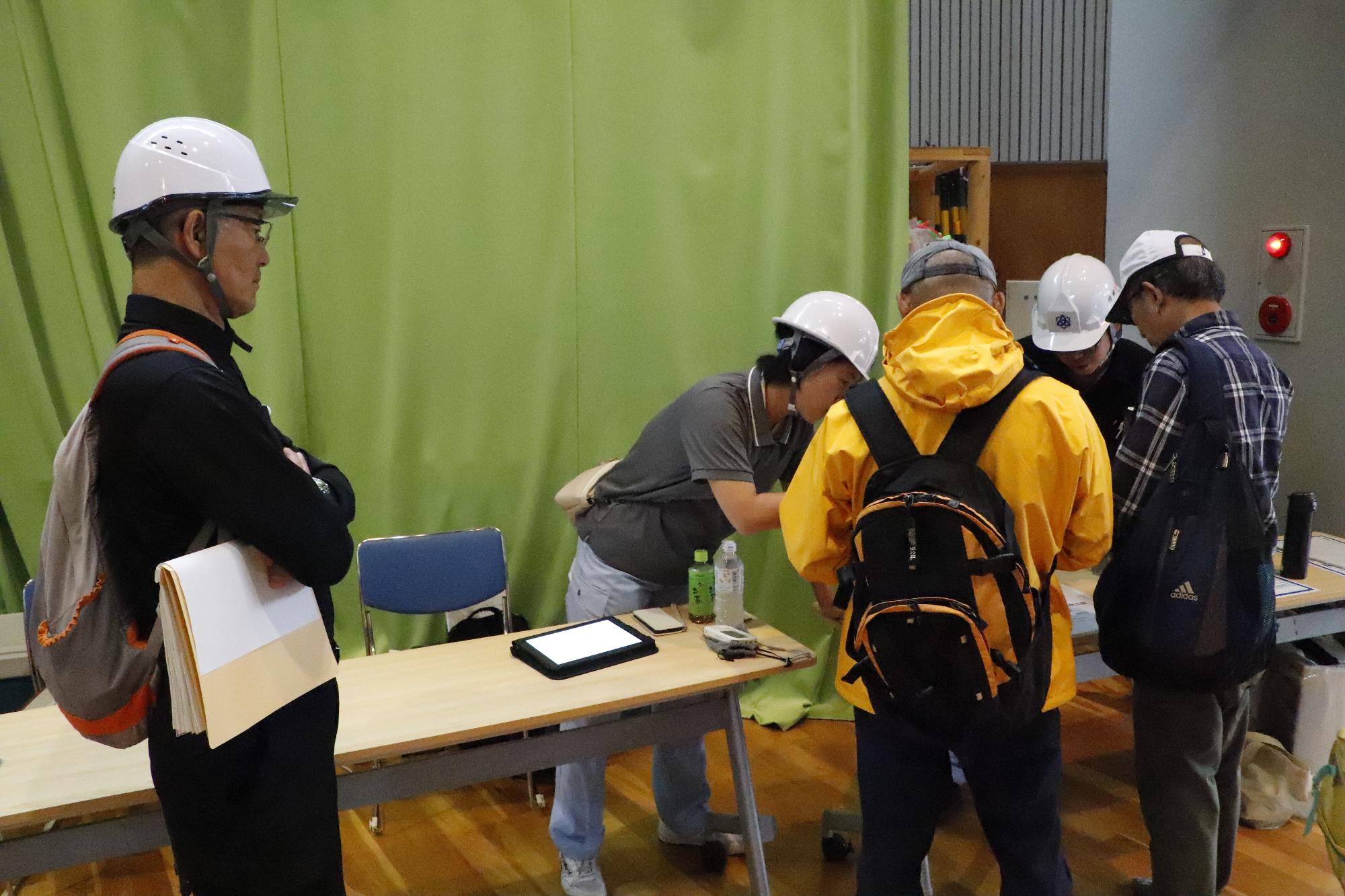 写真：避難者を受け入れる市職員とその様子を視察する櫻井市長。