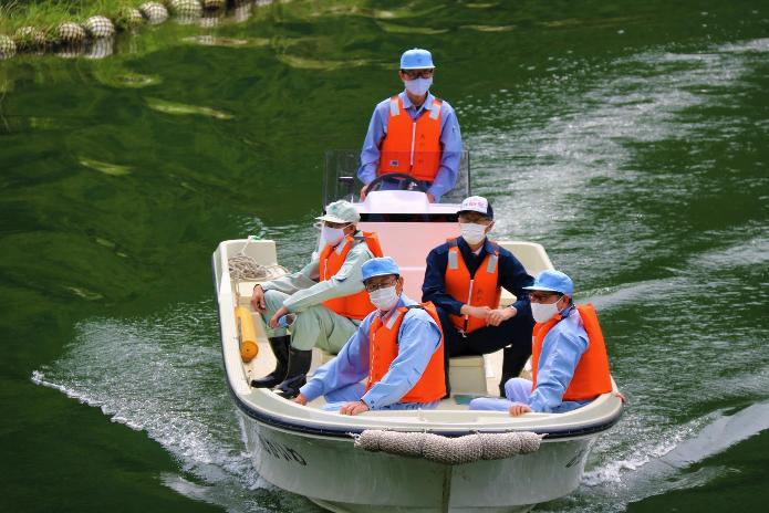 赤岩ダム湖の水上を、市長が乗ったボートが走っている写真