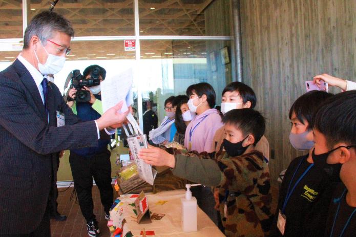 荒浜小学校3年生から購入した越後バナーナを受け取る市長の写真