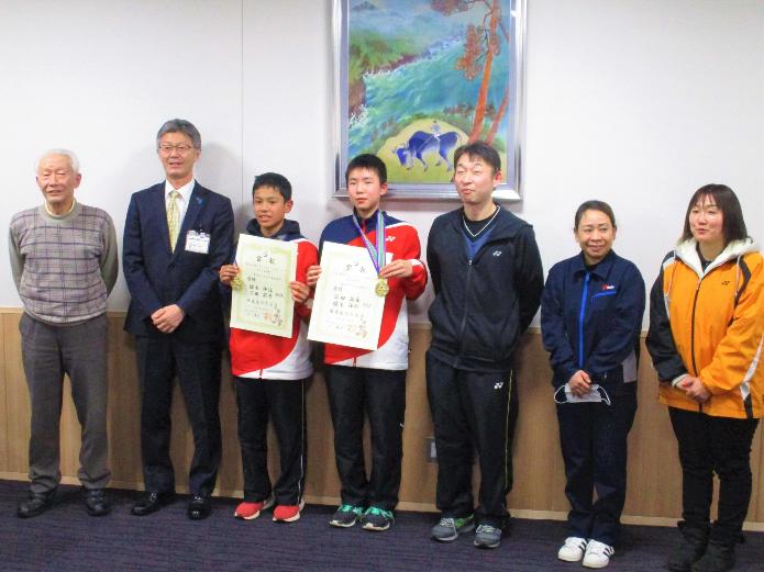 左から柏崎バドミントン協会会長、市長、賞状とメダルを手に持つ柏崎ジュニア選手2名、監督、選手母2名が一列に並んでいる写真