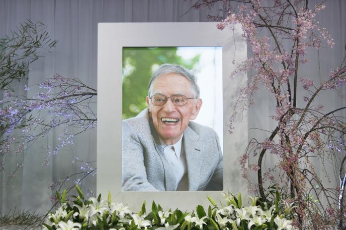 ドナルド・キーン先生の遺影の周りに桜の花やユリの花が飾られている写真