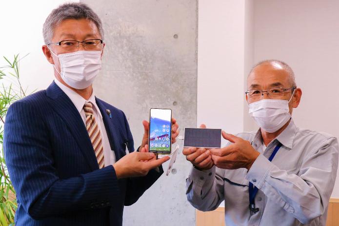 寄贈されたソーラーモバイルバッテリーを手に持つ市長と後藤柏崎トンネル作業所長の写真